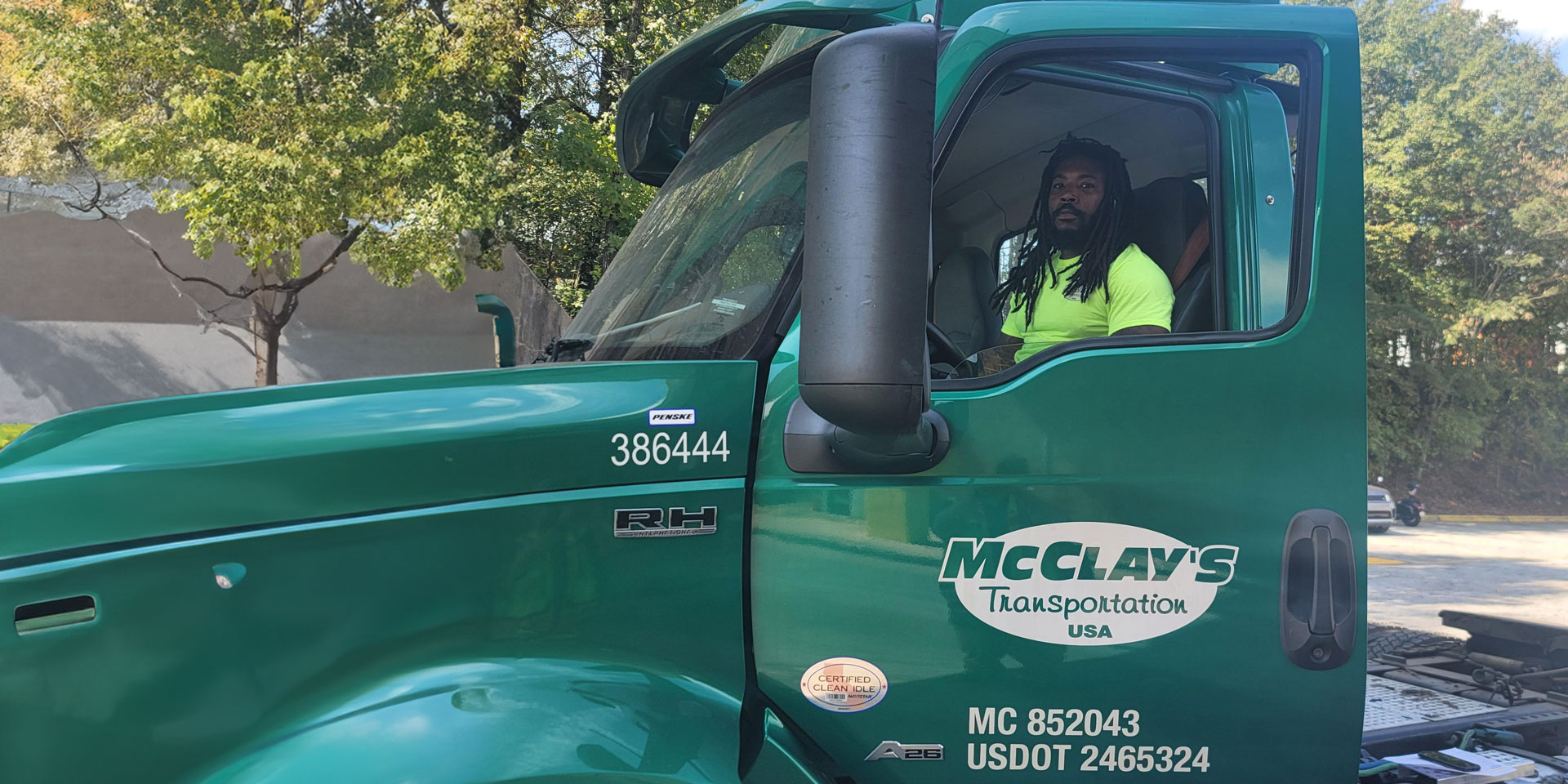 McClay's truck driver behind the wheel of a green semi truck