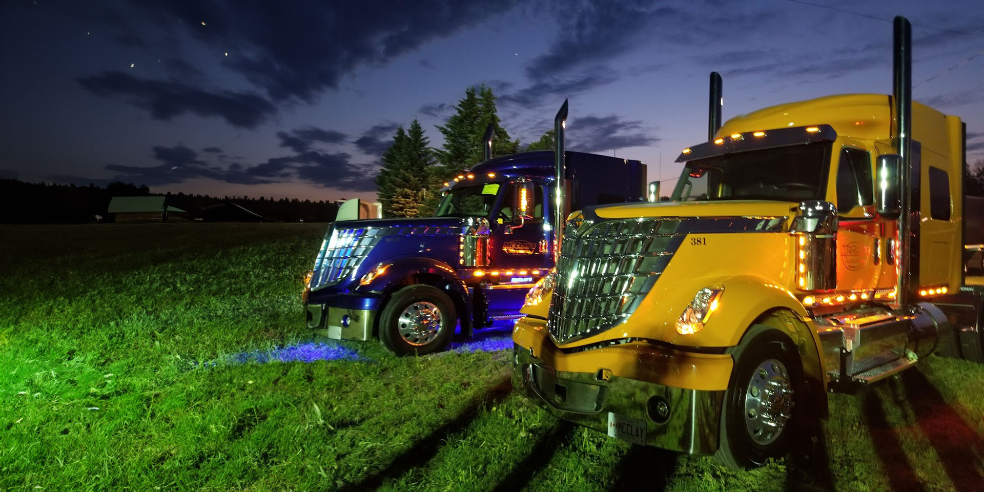 McClay's semi trucks parked in a grassy field at night