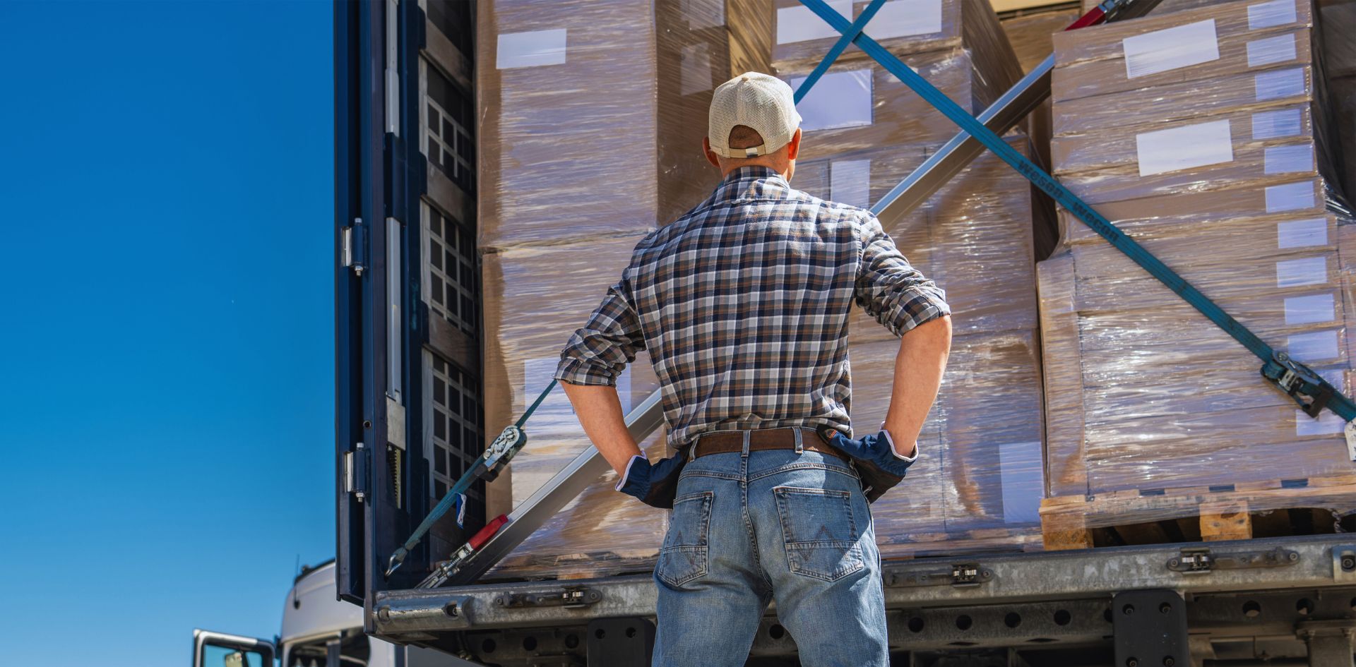 A trucker looking at a secured load in his trailer before locking the trailer door